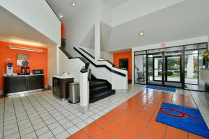 a living room with a staircase and orange walls at Motel 6-Plano, TX - West - Frisco in Plano
