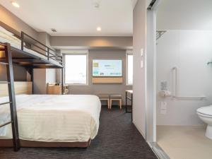 a bedroom with a bunk bed and a bathroom at Super Hotel Nagoya Shinkansenguchi in Nagoya