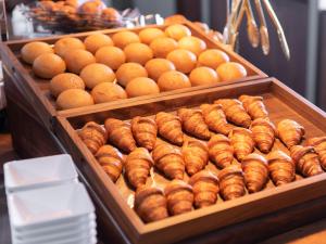 a display case with lots of rolls and oranges at Super Hotel Nagoya Shinkansenguchi in Nagoya