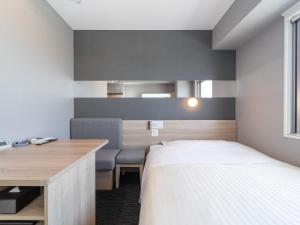 a bedroom with a bed and a desk and a bed sidx sidx sidx at Super Hotel Nagoya Shinkansenguchi in Nagoya