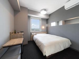 a bedroom with a large bed and a window at Super Hotel Nagoya Shinkansenguchi in Nagoya