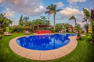 a swimming pool in a yard with a gazebo at El Chante Spa Hotel in Jocotepec