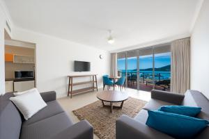 un soggiorno con un divano e un tavolo di The Sebel Whitsundays ad Airlie Beach