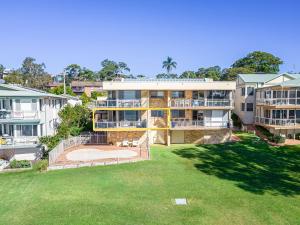 an aerial view of a building with a large yard at Pelican Sands 2 fantastic waterfront unit with pool and air conditioning in Soldiers Point
