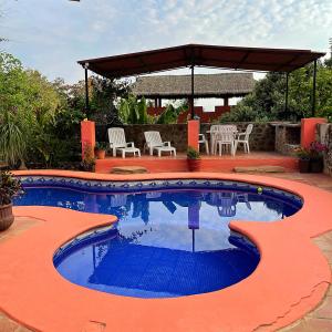 a swimming pool in a patio with a table and chairs at Casa Monarca in Chacala
