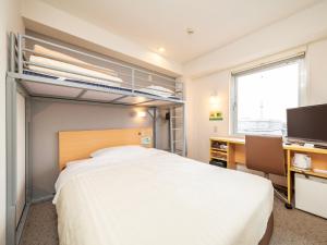 a bedroom with a large white bed and a desk and a window at Super Hotel Ueno-Okachimachi in Tokyo