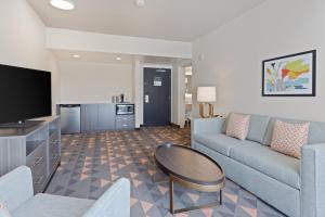 a living room with a couch and a table at Holiday Inn & Suites Across from Universal Orlando by IHG in Orlando