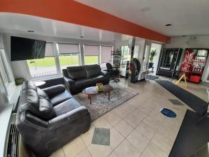 a living room with a leather couch and a tv at Howard Johnson by Wyndham Woodstock NB in Woodstock