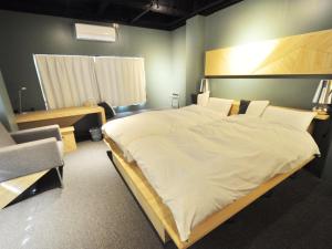 una camera da letto con un grande letto bianco in una stanza di SINGAI CABIN a Onomichi