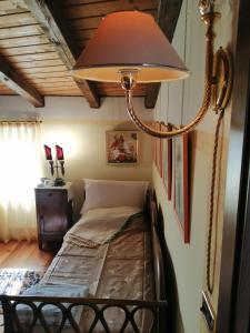 una camera da letto con un letto con una lampada a muro di BeB da Paolo con vista Lago a San Zeno di Montagna