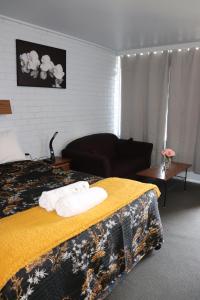 Habitación de hotel con cama con manta amarilla en Edenhope Motor Inn en Edenhope