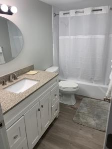 a bathroom with a sink and a toilet and a mirror at The Chugach at 1400K in Anchorage