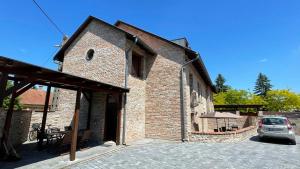 a brick building with a car parked in a parking lot at Marcell Apartman in Gyula