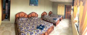 a room with four beds with blue flowers on them at La Casa de Jeimy in Puerto Baquerizo Moreno