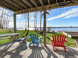 three colorful chairs and a picnic table on a patio at Scenic Harbour View House in Stratford