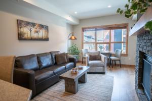 uma sala de estar com um sofá e uma lareira em Spring Creek Luxury Queen Suite at White Spruce Lodge em Canmore