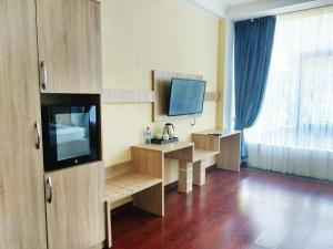 Cette chambre comprend un bureau et une télévision. dans l'établissement Park Hotel al Bustan, à Chimkent