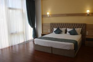 سرير أو أسرّة في غرفة في Park Hotel al Bustan