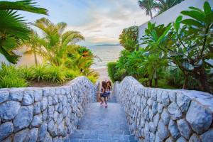 two girls walking down a stone path towards the beach at AnB poolvilla 2BR with private beach in pratamnak in Pattaya South