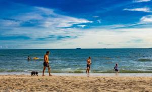 a group of people on the beach with a dog at AnB poolvilla 2BR with private beach in pratamnak in Pattaya South