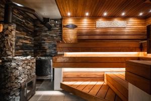 a sauna with wood paneling and a stone wall at Soomaa Puhkeküla in Riisa