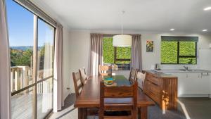 a kitchen and dining room with a table and chairs at Kapiti Views - Waikanae Beach Holiday Home in Waikanae