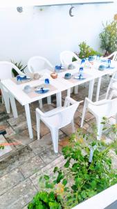 a white table and chairs with plates and bowls on it at A casa di Gio in Lecce