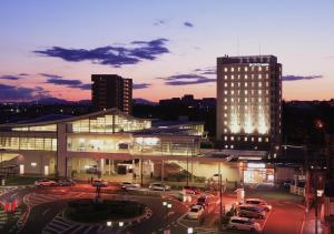 a large building with cars parked in a parking lot at Life Inn Katsuta Station West in Hitachinaka