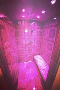 a purple room with a shower in a bathroom at Stodingerhütte in Winkl