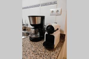 una macchinetta del caffè su un bancone in cucina di Apartamento a 100 m de playa. Calella Palafrugell a Calella de Palafrugell