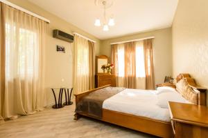 a bedroom with a bed and a desk and windows at Rustaveli Two Bedroom Apartment with 5 Star Location in Tbilisi City