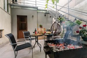 a patio with a table and chairs and a fire pit at Rustaveli Two Bedroom Apartment with 5 Star Location in Tbilisi City
