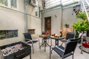 a patio with chairs and tables and a fireplace at Rustaveli Two Bedroom Apartment with 5 Star Location in Tbilisi City