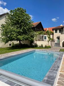 a swimming pool in a yard with a tree at Renaissancehof Wieser Wachau in Wösendorf