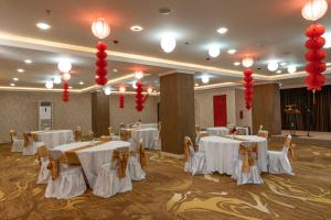 a banquet hall with white tables and red decorations at Goldvitel Hotel Surabaya in Surabaya +36 photos