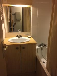 a bathroom with a sink and a mirror and a tub at studio cabine Praz de Lys in Taninges