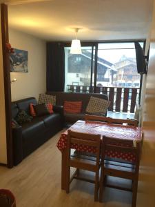 uma sala de estar com um sofá e uma mesa em studio cabine Praz de Lys em Taninges