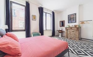 a bedroom with a pink bed and a fireplace at Lyves in Liège
