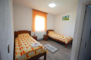 a small bedroom with two beds and a window at Atyha Kiss Csalad Lak Agropanzio in Atia