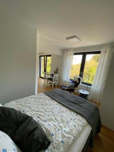 a bedroom with a bed and a room with windows at Waldurlaub Klingelborn im Sauerland in Balve