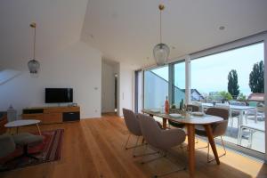 a living room with a table and chairs and a television at See-Flair in Immenstaad am Bodensee
