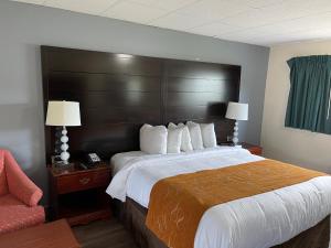 una habitación de hotel con una cama grande y una silla en Bedford Motel, en Bedford