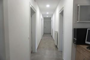 pasillo con paredes blancas y TV en una habitación en Maister Rooms, en Maribor