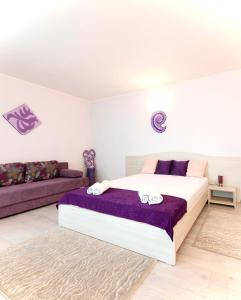 a bedroom with a large bed and a couch at Vila Adriana in Eforie Nord