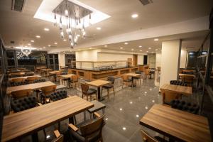 加济安泰普Divares Luxury Hotel的一间空荡荡的餐厅，摆放着木桌椅 更多16张照片