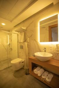 加济安泰普Divares Luxury Hotel的浴室配有盥洗池、卫生间和镜子。