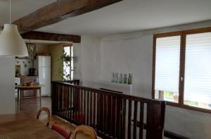 a kitchen and living room with a dining table and windows at Montségur ARIEGE grande maison éco-rénovée in Montségur