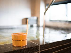an orange cup sitting on top of a pool of water at Super Hotel Nagoya Shinkansenguchi in Nagoya