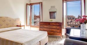 a bedroom with a bed and a dresser and windows at Pensione Seguso in Venice