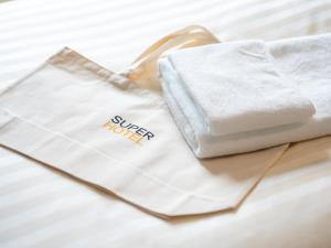 a white bag sitting on top of a bed at Super Hotel Nagoya Shinkansenguchi in Nagoya